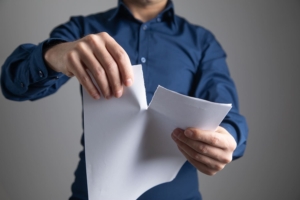 Persona che strappa un documento che simboleggia un testamento che si vuole contestare.